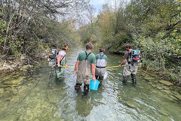 štirje raziskovalci z opremo za vzorčenje stojijo v vodi