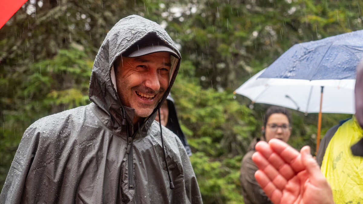 nasmejan član projekta JeloviZA v dežju na terenu